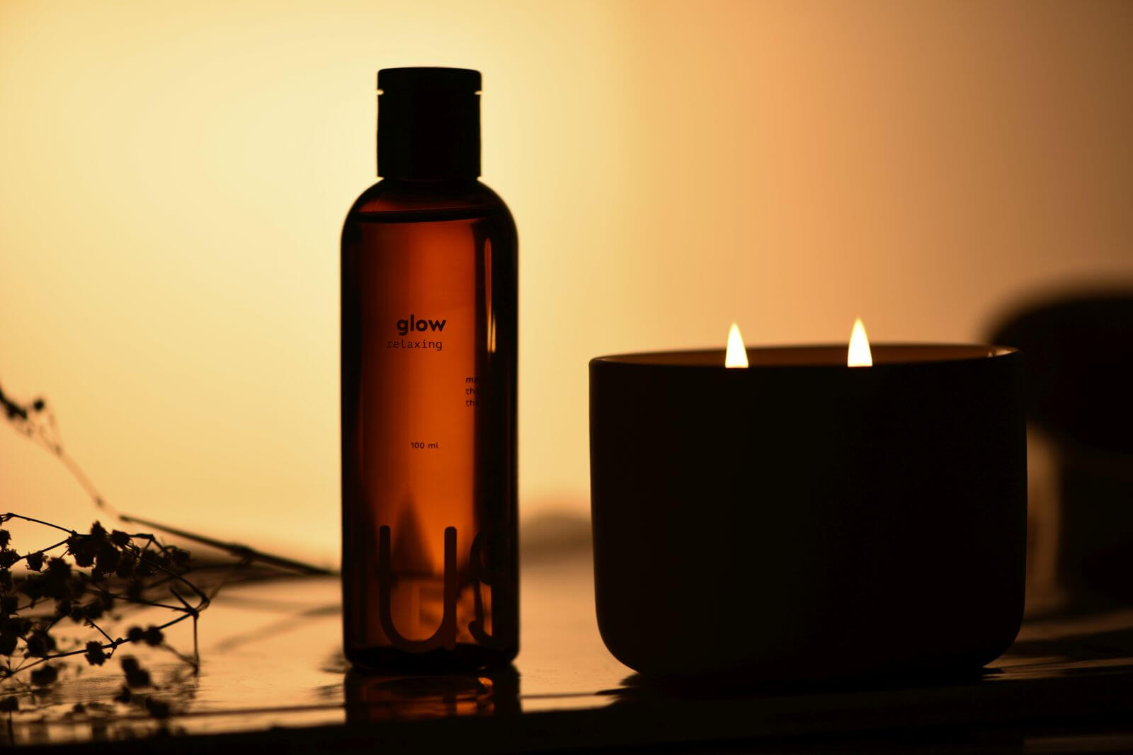 Massage oil and candle in dim light