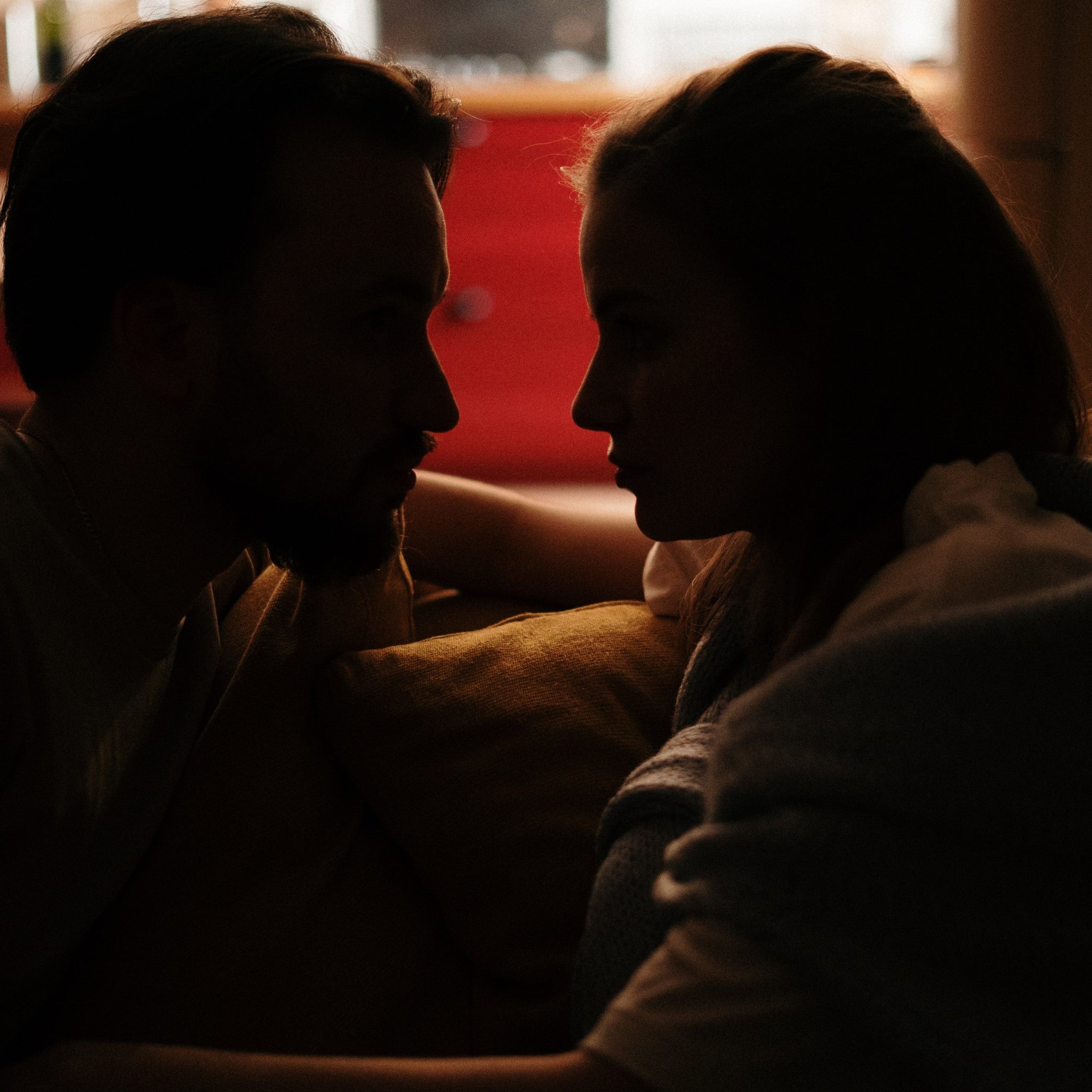 Man and woman staring at each other in a dark room