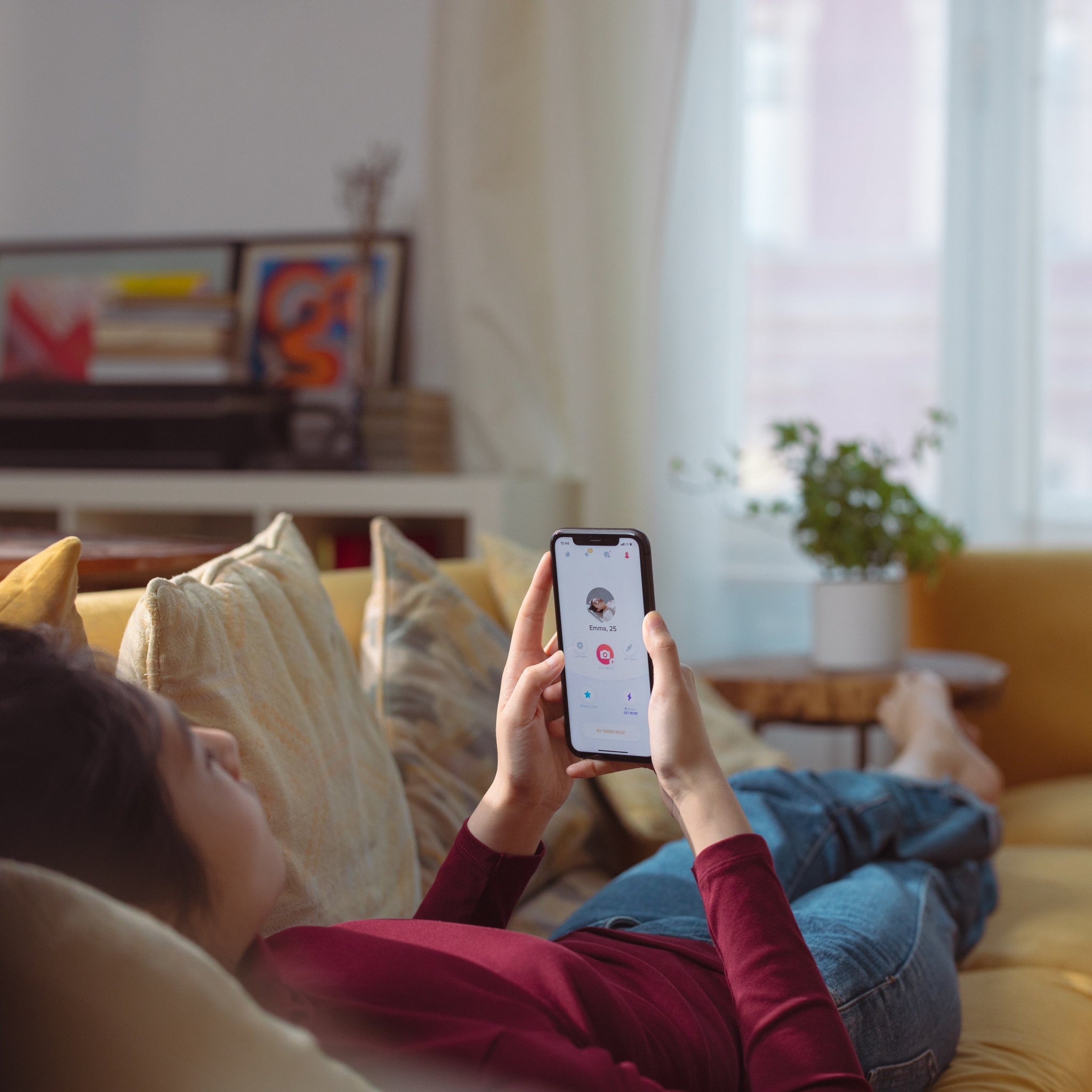 A person lying on the sofa and swiping on a dating app 