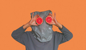 Person with bag on their head looking through oranges