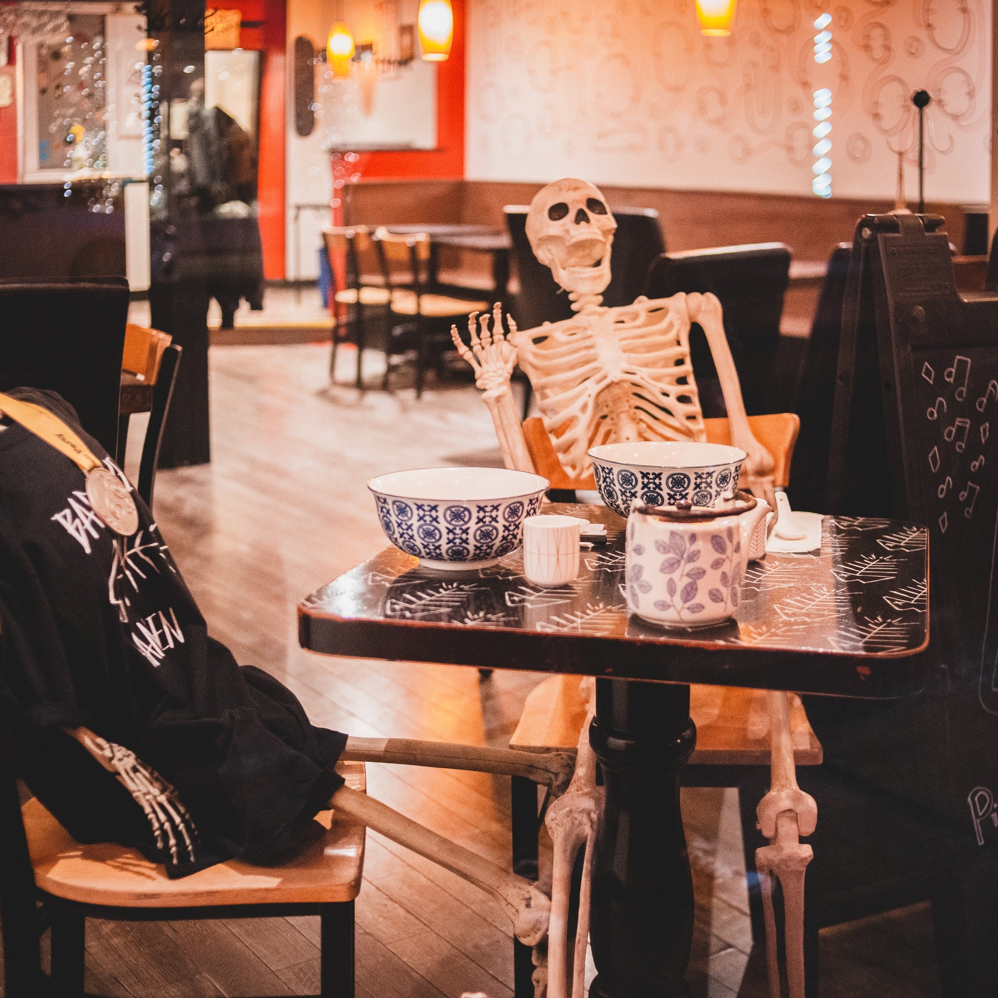 Skeletons placed at a table with dishware