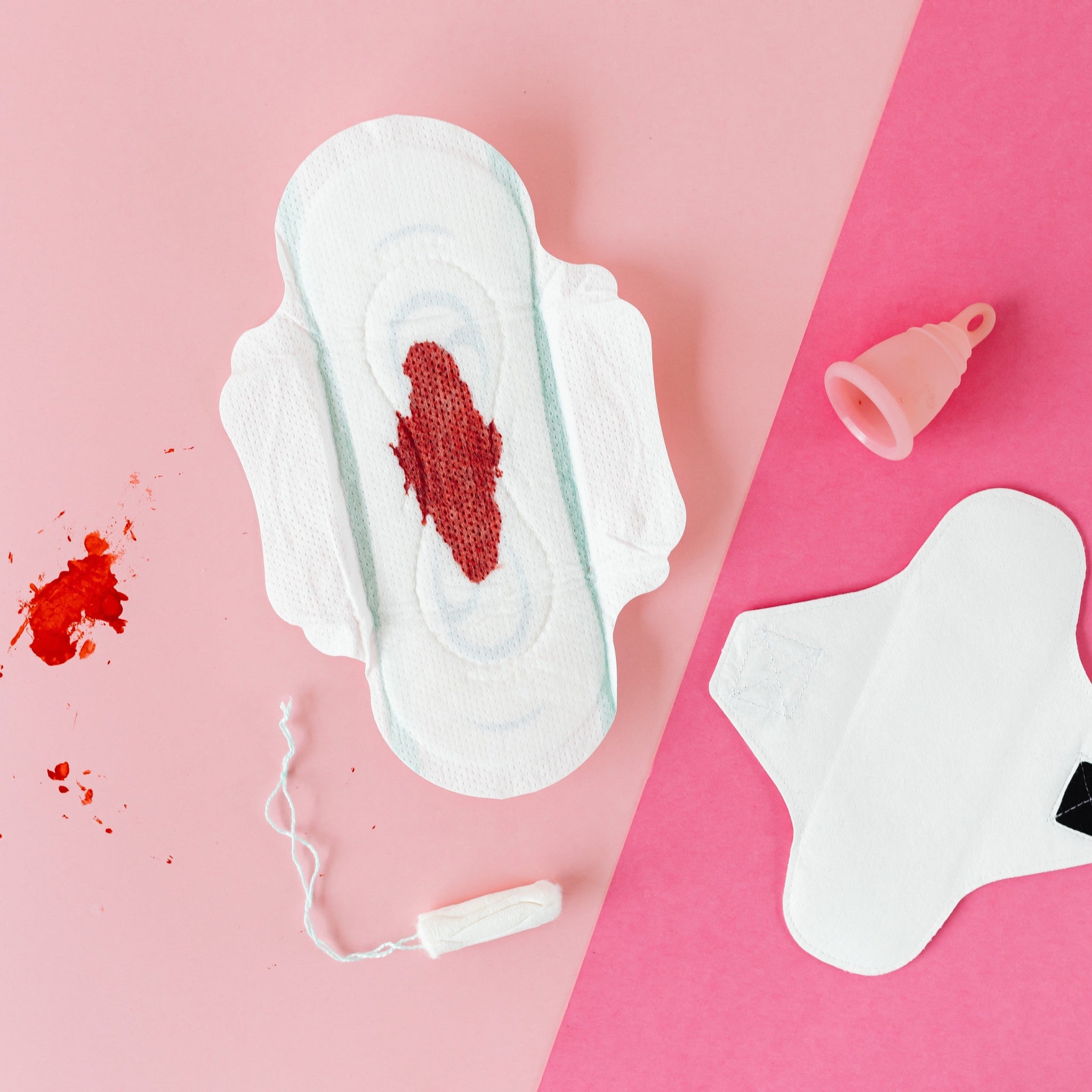 A Pad With Period Blood On It As A Tampon & A Period Cup Lie Around