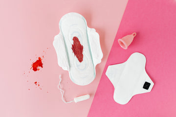 A Pad With Period Blood On It As A Tampon & A Period Cup Lie Around