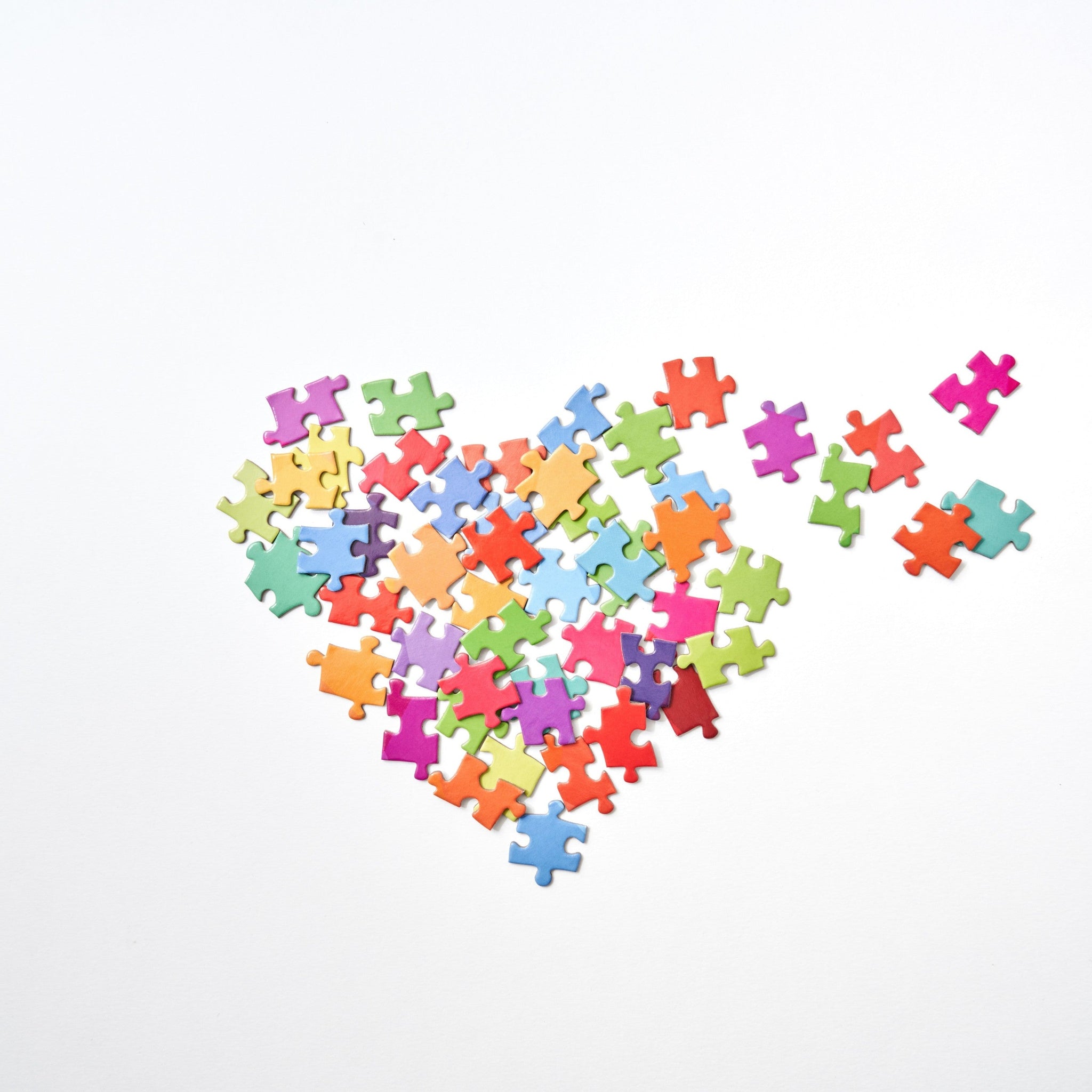 Broken heart-shaped puzzle pieces in a white background