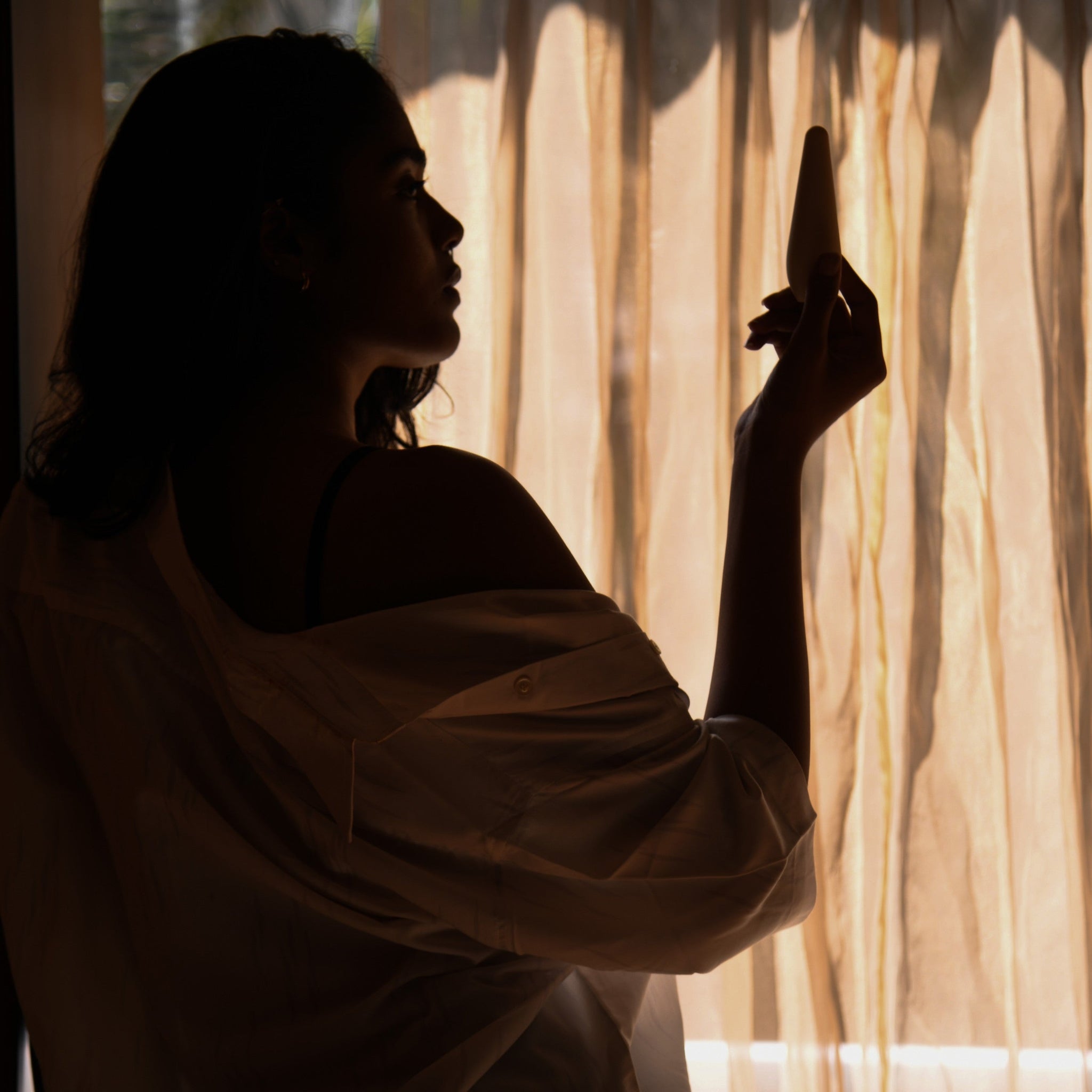 A woman holding MyMuse’s Pulse massager