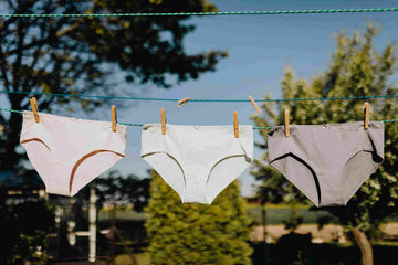 Feminine underwear drying on rope with clothespins on fresh air