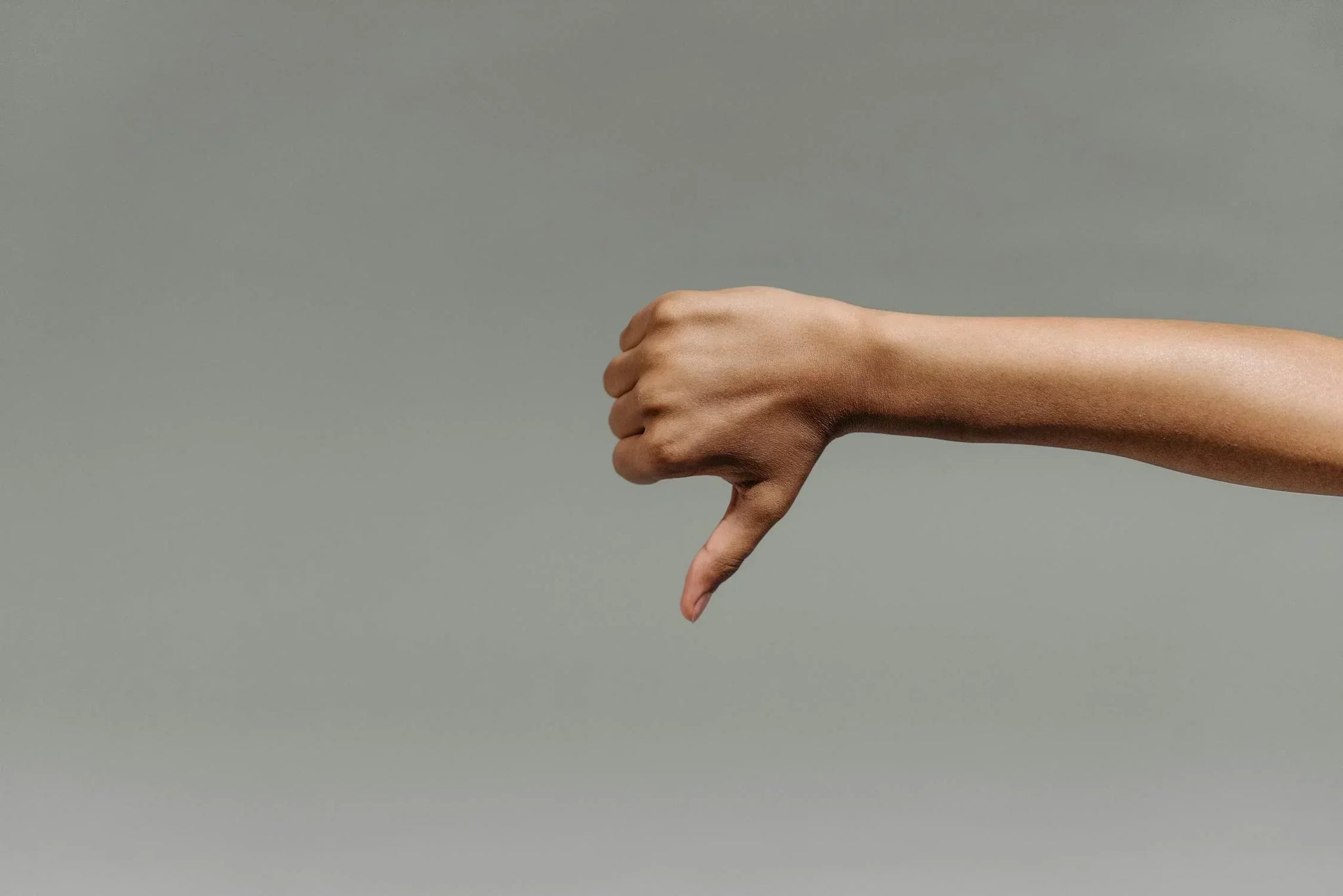 A person giving a thumb down to represent giving feedback in the bedroom